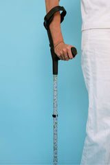 Person holding a walking stick against a light blue background