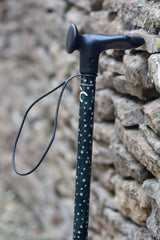 Green adjustable walking stick with a star pattern showing a close up or ergonomic handle and wrist strap