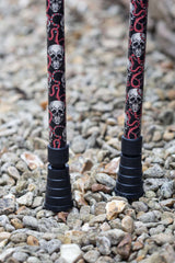 Bottom of pair of black crutches with skull and snake design showing ferrule