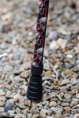 Bottom of black walking stick with a skull and snakes design showing ferrule