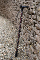 Black walking stick with a skull and snakes design