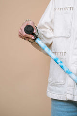 Person holding a blue light sky walking stick with ergonomic handle against a beige background