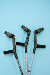 Three crutches with patterned grips on a blue background