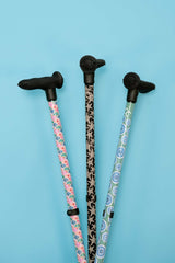 Three ergonomic walking sticks with patterned handles on a blue background