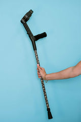 Cane held by a hand against a blue background