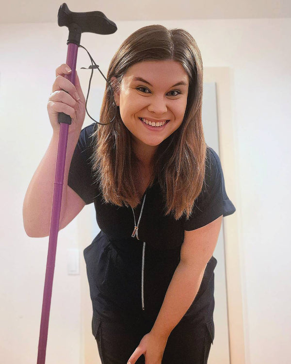 Girl holding purple folding walking stick from Cool Crutches
