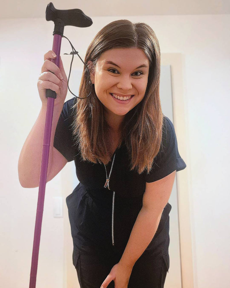 Girl holding purple folding walking stick from Cool Crutches