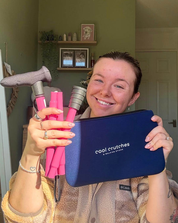 Woman holding pink folding walking stick from Cool Crutches