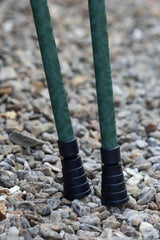 Bottom of green camo designed pair of adjustable crutches showing ferrules