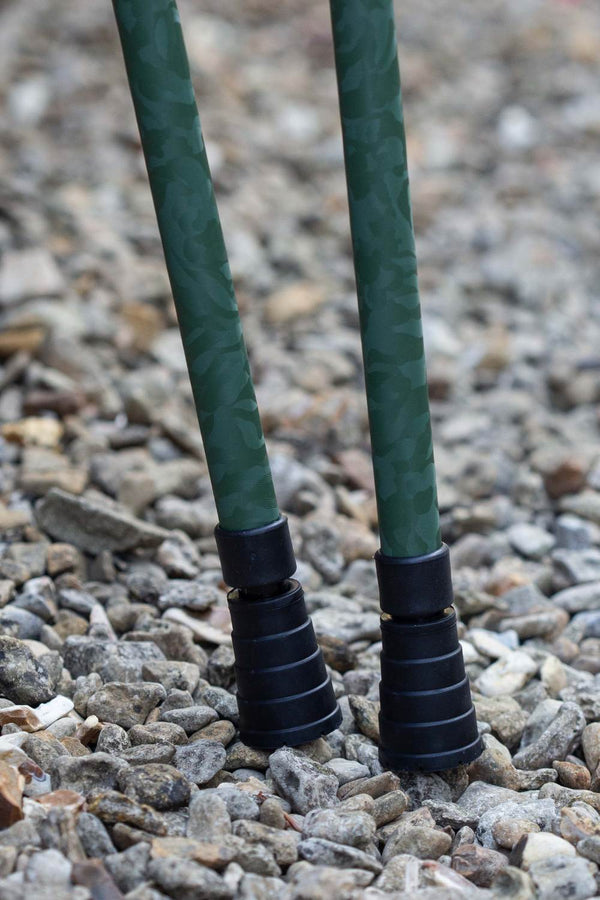 Bottom of green camo designed pair of adjustable crutches showing ferrules