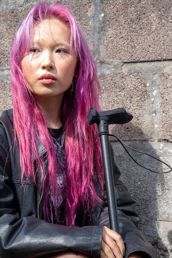 Person holding black leather effect walking stick from cool crutches