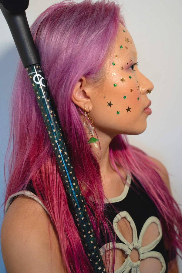 Person holding dark green crutches covered in gold stars from cool Crutches