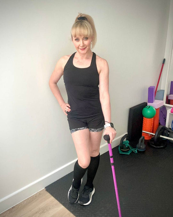 Woman stood with purple folding walking stick