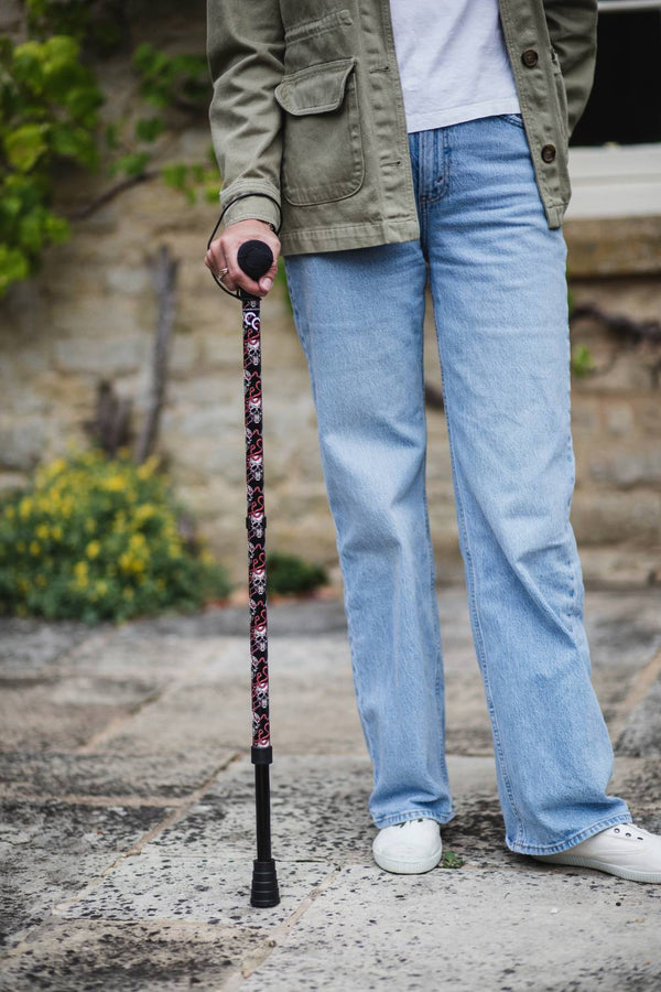 Black walking stick with a skull and snakes design