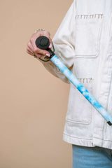 Person holding a blue sky walking cane against a beige background
