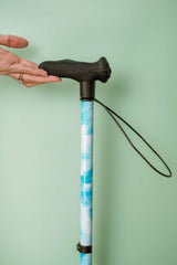 Cane with blue and white patterned shaft against a green background