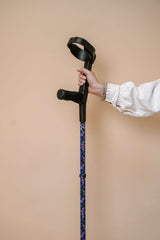 Cane held by a hand against a beige background