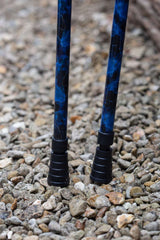 The bottom of a pair of crutches designed with deep ocean blues and streaks of gold lightning showing ferrules