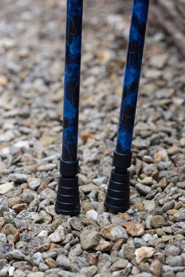 The bottom of a pair of crutches designed with deep ocean blues and streaks of gold lightning showing ferrules