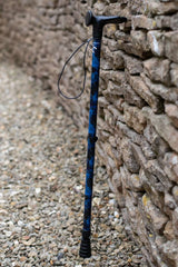 A walking stick with a blend of deep ocean blues and electric gold lightning streaks